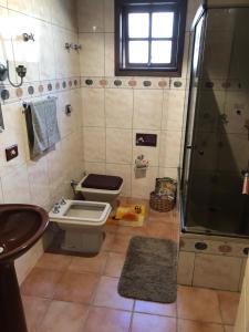 uma casa de banho com um WC, um chuveiro e um lavatório. em Casa Moinhos de Vento Vintage em Porto Alegre