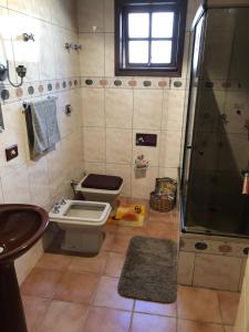 a bathroom with a toilet and a shower and a sink at Casa Moinhos de Vento Vintage in Porto Alegre