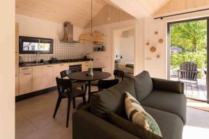 a living room with a couch and a table at Fred I Tiny House op de Veluwe in Epe