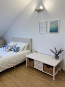 a bedroom with two beds and a white table at Pinares de Boo in Boó de Piélagos