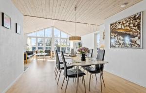 3 Bedroom Beautiful Home In Frederikshavn في فريكشهاون: غرفة طعام وغرفة معيشة مع طاولة وكراسي