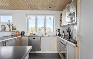 a kitchen with white cabinets and a sink at Amazing Home In Frederikshavn in Frederikshavn