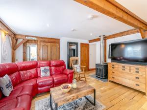 a living room with a red couch and a flat screen tv at The Lodge in Gloucester