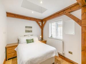 a bedroom with a white bed and a window at The Lodge in Gloucester