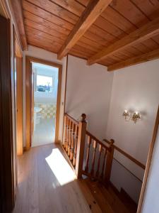 a staircase in a house with a wooden ceiling at Pinares de Boo in Boó de Piélagos