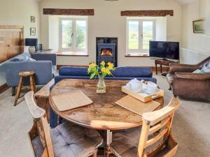 uma sala de estar com uma mesa e uma lareira em Cefn Canol em Betws-y-coed