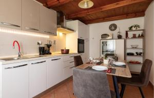 eine Küche mit einem Holztisch und weißen Schränken in der Unterkunft Awesome Home In Barban With Jacuzzi in Divšići