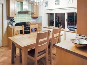 a kitchen with a wooden table and chairs at Pipers Cottage in Beyton