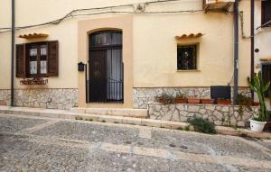 ein Haus mit einer schwarzen Tür in einer Kopfsteinpflasterstraße in der Unterkunft Stunning Home In Trappeto With Wifi in Trappeto