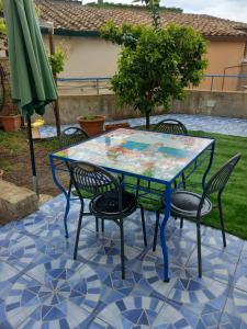 - une table et des chaises sur une terrasse avec un parasol dans l'établissement Casa Mery, à Vietri
