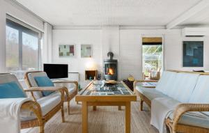 sala de estar con sofá, mesa y chimenea en 3 Bedroom Gorgeous Home In Vejby, en Vejby