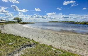 een zandstrand naast een waterlichaam bij Pet Friendly Home In Lauwersoog in Lauwersoog