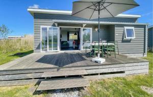 een huis met een terras met een tafel en een paraplu bij Pet Friendly Home In Lauwersoog in Lauwersoog