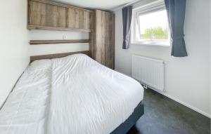 sypialnia z białym łóżkiem i oknem w obiekcie Pet Friendly Home In Lauwersoog w mieście Lauwersoog +17 zdjęć