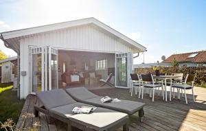 a patio with a table and chairs on a deck at Three-Bedroom Holiday Home In Knebel in Knebel +25 photos