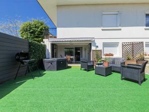 a yard with green grass in front of a house at Appartement Le Maro in Saubusse