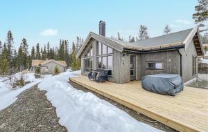 une maison sur une terrasse en bois dans la neige dans l'établissement Pet Friendly Home In Gl With Kitchen, à Gålå
