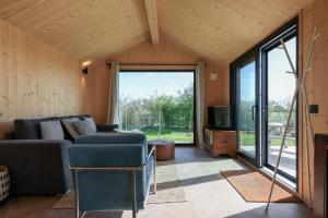 ヴェストカペレにあるHello Zeeland - Tiny House Zeeuwse Liefde 2のソファとテレビのあるリビングルーム