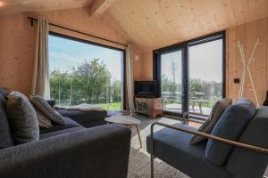 ヴェストカペレにあるHello Zeeland - Tiny House Zeeuwse Liefde 2のリビングルーム(ソファ2台、大きな窓付) +12枚の写真