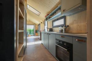 a kitchen with a sink and a stove at Hello Zeeland - Tiny House Zeeuwse Liefde 2 in Westkapelle