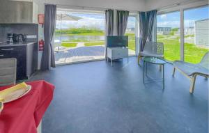 a living room with a television and a table and chairs at 2 Bedroom Awesome Home In Lauwersoog in Lauwersoog