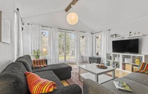 uma sala de estar com um sofá e uma mesa em Nice Home In Sby With Kitchen em Sæby