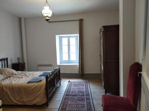 1 dormitorio con cama y ventana en Grès Vaillant, en Saint-Polycarpe