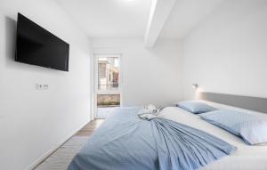 a white bedroom with a bed with a cat sitting on it at 3 Bedroom Stunning Apartment In Vodice in Vodice