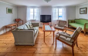 uma sala de estar com um sofá e cadeiras e uma televisão em Beautiful Home In Bergkvara With House Sea View em Bergkvara