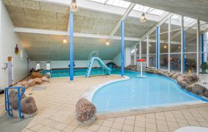 een groot binnenzwembad met een glijbaan in een gebouw bij 2 Bedroom Nice Home In Hemmet in Hemmet