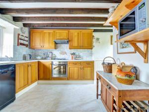 a kitchen with wooden cabinets and a counter top at Uk47176 - Vine Barn in Bellerby