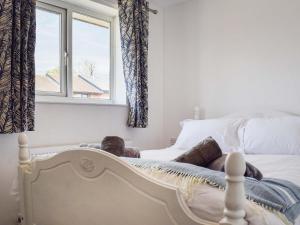 a person laying on a bed with a window at Racing Retreat in Towcester