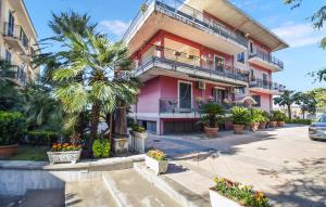 un edificio rosa con palme di fronte di Nice Apartment In Angri With Wifi ad Angri