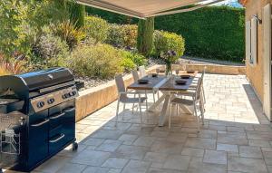 a patio with a grill and a table with chairs at 3 Bedroom Awesome Home In Puy-saint-martin in Puy-Saint-Martin