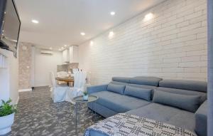 sala de estar con sofá azul y pared de ladrillo en Cozy Apartment In Makarska With Kitchen en Makarska