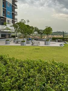 a park with benches and trees in front of a building at Skylake Residence Luxury Family Vacation in Puchong