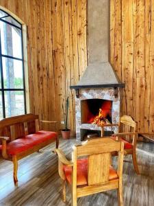 a living room with a fireplace in a wooden wall at Sinà-Poas Green Chalets in Fraijanes