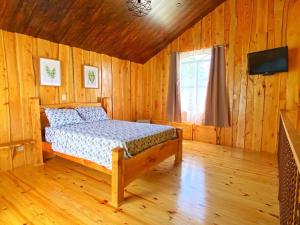 a bedroom with a bed in a wooden room at Poas Green Chalets in Fraijanes