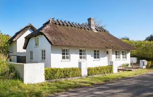 Biały dom z dachem krytym strzechą na ulicy w obiekcie 2 Bedroom Cozy Home In Haarby w mieście Hårby