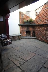 a patio with a brick fireplace and a chair at 5 Corners Guest Inn in Ballyclare