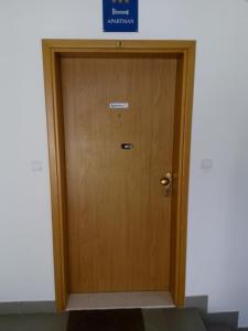 una puerta de madera en un edificio con un cartel en Apartment Z&E, en Trogir