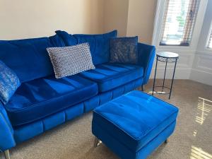 紹斯波特的住宿－The New Talbot Hotel，客厅里一张蓝色的沙发和搁脚凳