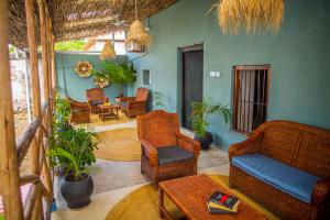 a living room with wicker chairs and a table at Firefly West Wing in Bagamoyo