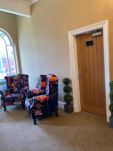 dwa krzesła siedzące w pokoju z drzwiami w obiekcie The New Talbot Hotel w mieście Southport