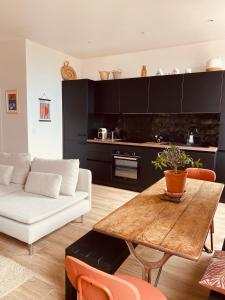 - un salon avec un canapé blanc et une table en bois dans l'établissement Charming apartment - Sea view, au Cannet