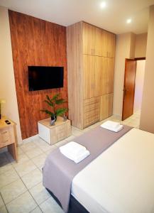 een slaapkamer met een groot bed en een tv bij Relaxed Dream home in Chania