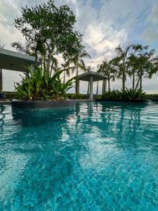 a large blue swimming pool with trees and a gazebo at Skylake Residence Luxury Family Vacation in Puchong