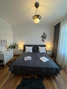 a bedroom with a large bed with two towels on it at Apartament ALMAR Cieplice-Zdrój in Jelenia Góra