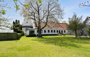 duży biały dom z drzewem w ogrodzie w obiekcie 3 Bedroom Lovely Home In Svendborg w mieście Svendborg