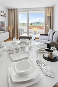 a table with white plates and utensils on it at Flexi Home - Balkon , Seeblick & Speed Wlan in Langscheid